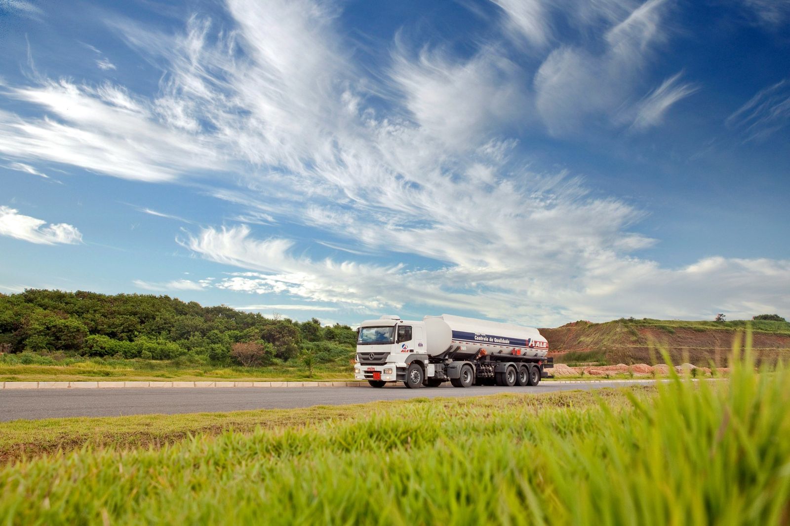 Fuel tanker truck on a road under a wide blue sky
